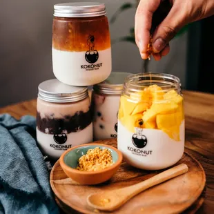 a person putting a spoon into a jar of yogurt