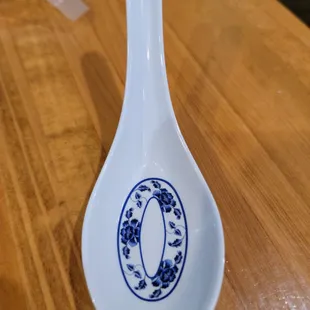 a blue and white spoon on a wooden table