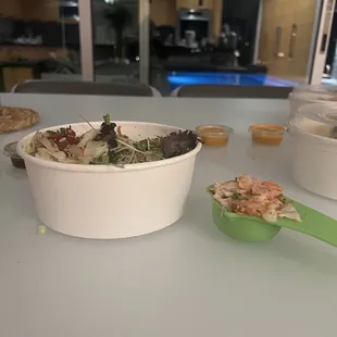 a bowl of salad and a spoon of salad