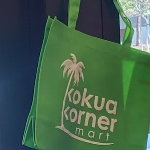 a green tote bag hanging on a door