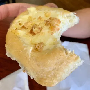 a hand holding a half eaten donut