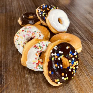 a variety of doughnuts on a wooden table