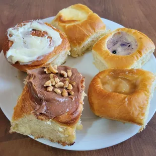 Ferrero Rocher Cinnamon Roll, Cinnamon Roll, Sweet Cheese Kolache, Blueberry Sweet Cheese Kolache, and Butterscotch Pear Kolache.