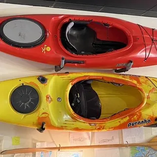 three kayaks hanging on a wall