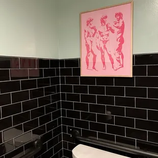 a toilet in a black tiled bathroom