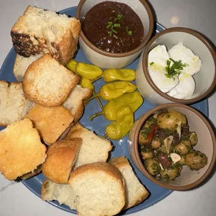 a plate of bread, soup, and bread rolls