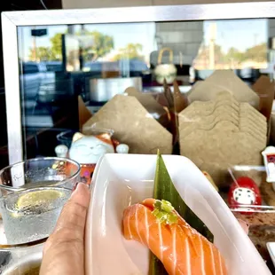 a person holding a plate of sushi