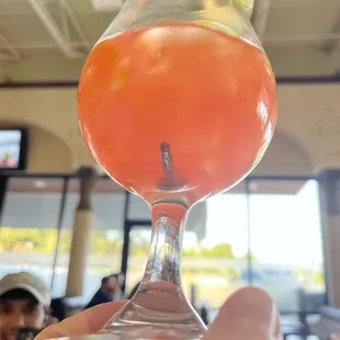 a person holding a drink in a glass