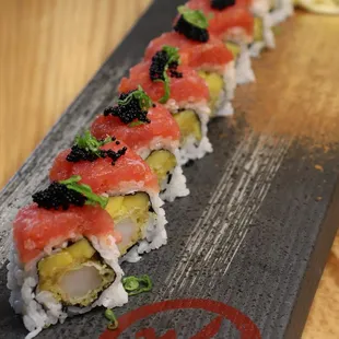 a sushi roll with salmon and avocado