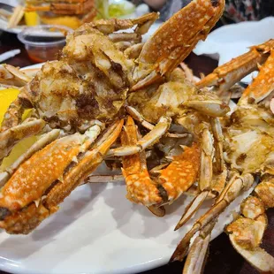 crab legs on a plate with lemon wedges