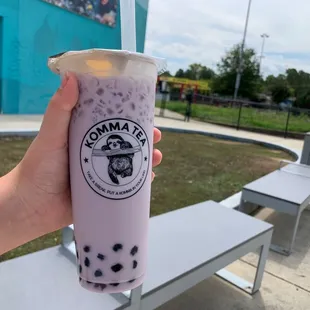 a hand holding a cup of bubble tea