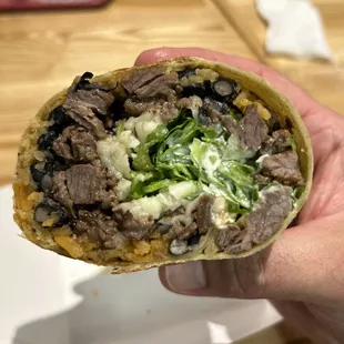 a hand holding a burrito