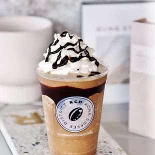 a cup of coffee with whipped cream and chocolate drizzle