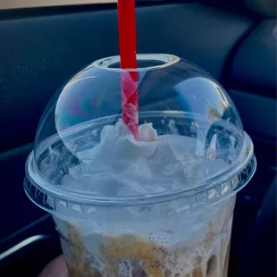 a hand holding a cup of iced coffee