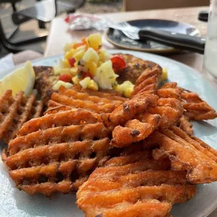 Mahi mahi with macadamia nut crust and a pile of sweet potato fries.