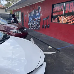 a white car parked in front of a red building