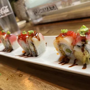 a row of sushi rolls on a white plate