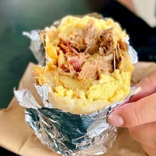 a person holding a burrito