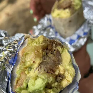 two burritos wrapped in aluminum foil