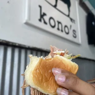 a hand holding a sandwich