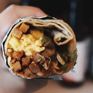 a hand holding a burrito