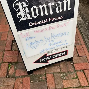 a sign on a brick sidewalk