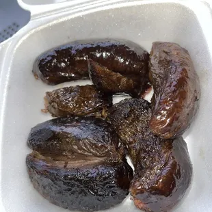 a variety of sausages in a styrofoam container