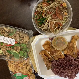 From left, laab chicken, papaya salad, fried chicken quarter with purple sticky rice