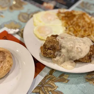 Country fried steak with over easy eggs, hash browns and an English muffin
