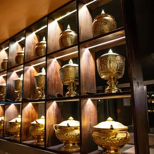 a wall of gold vases