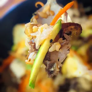 a close up of a forkful of food