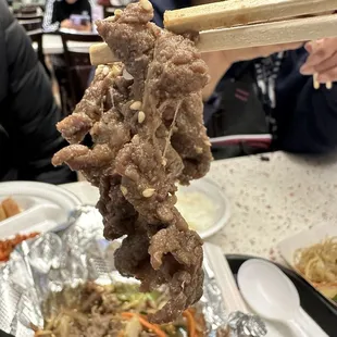 a person holding chopsticks over a plate of food