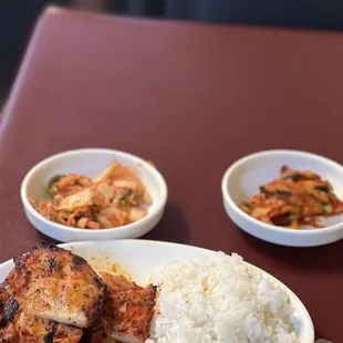 a plate of rice, chicken, and vegetables