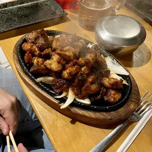 a person holding chopsticks in front of a plate of food