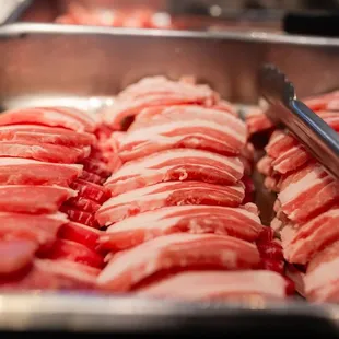 raw meat being prepared in a pan