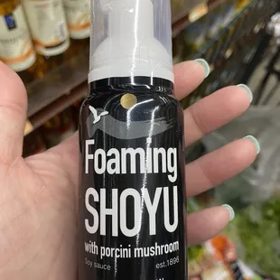 a hand holding a foaming shoyu