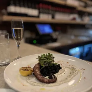 Grilled octopus, cannellini beans, truffle tapenade aioli, grilled lemon, shallots.