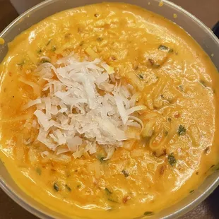a bowl of soup with shredded cheese