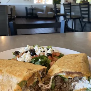 a burrito with a salad on a plate