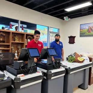 two men standing at a cash register