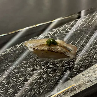 a piece of sushi on a piece of tin foil
