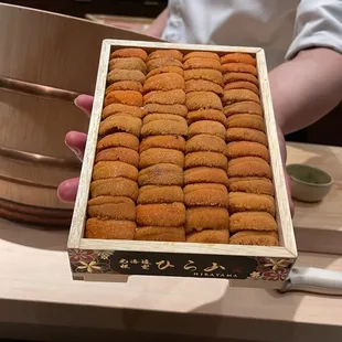 a person holding a box of cookies