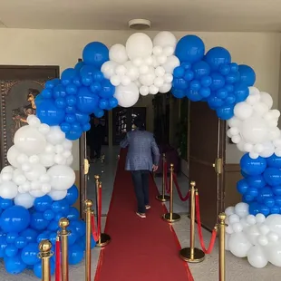 a red carpet and blue and white balloons