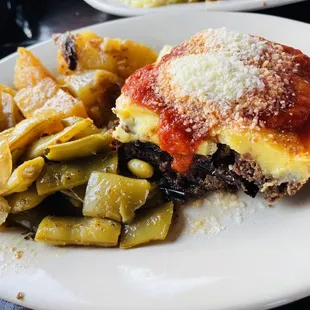a plate of lasagna and green beans