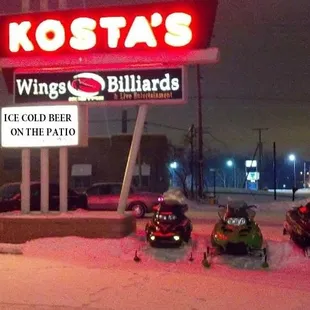 three snowmobilers parked in front of a restaurant
