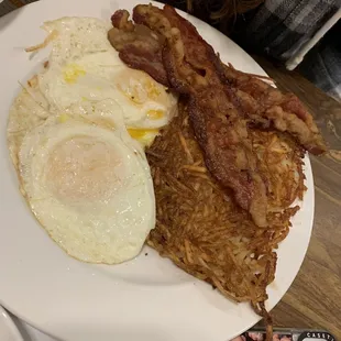 Three dippy eggs hash browns and bacon
