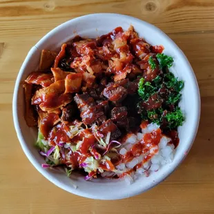 My customized bowl with bulgogi beef and Mexican steak. It has kale, kimchi, kotaco salad, onions, fish cake, and gochujang sauce.