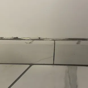 Gouges in the wall, grout at change of plane, and sloppy grout