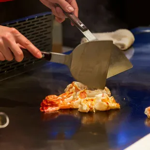 a person cutting a piece of pizza