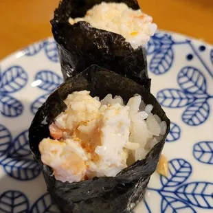 two pieces of sushi on a blue and white plate
